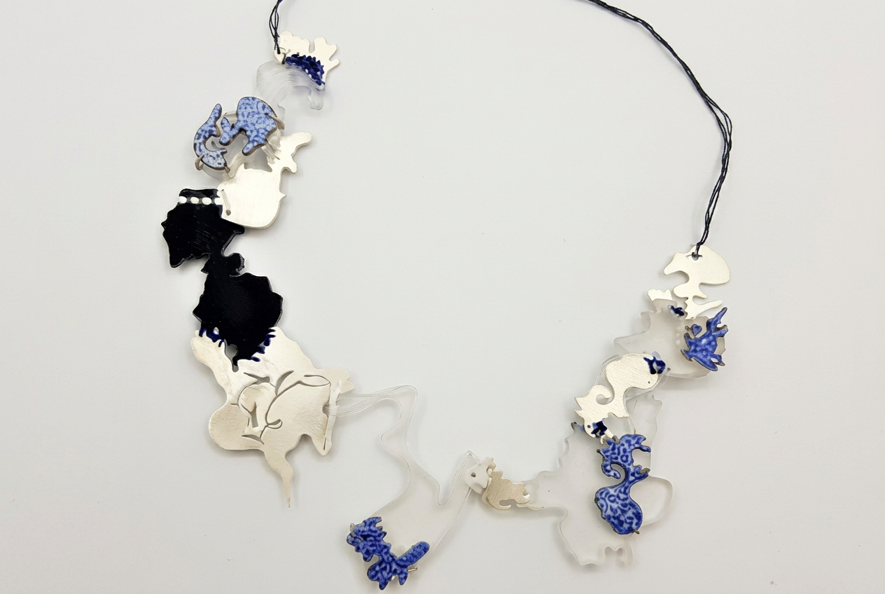 A Deeper Dive (2019) — necklace of porcelain, 925 silver, cobalt-patterned and black-inked segments strung on perspex and embroidery thread, from the Oupa-letters series.
