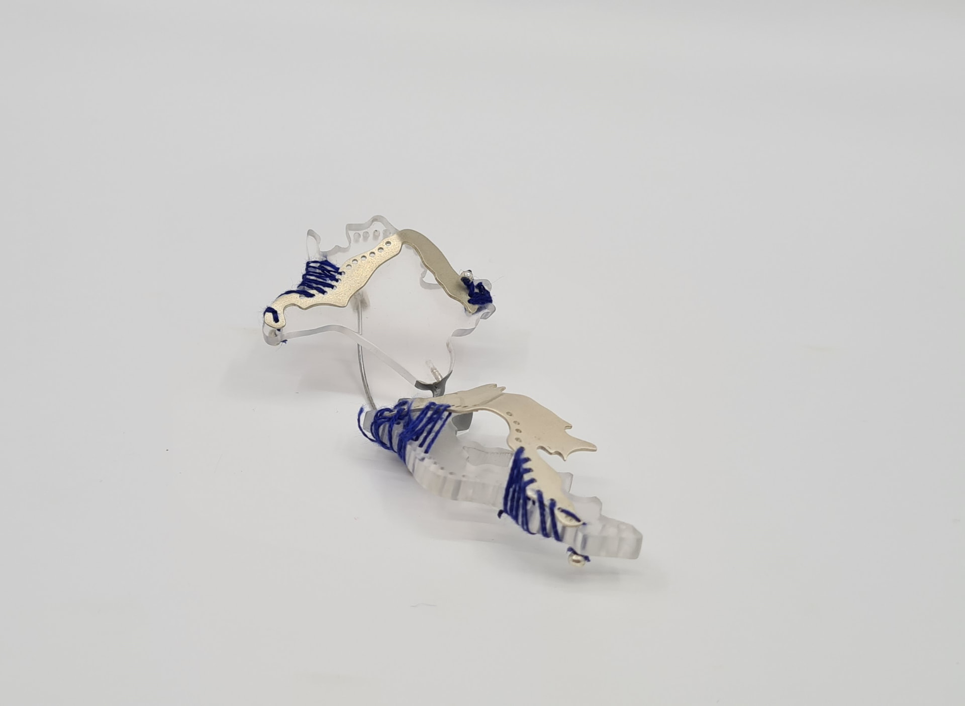 Pair of sterling silver and frosted acrylic brooches bound with cobalt blue thread, from the MAVA exhibition.